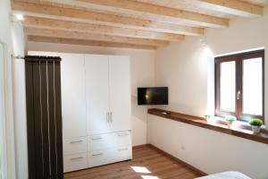 1 dormitorio con armarios blancos y TV en la pared en Monteleone Apartment, en Palermo