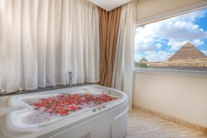La salle de bains est pourvue d'une baignoire remplie de poivrons rouges. dans l'établissement Soul Pyramids View, au Caire