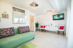 a living room with a green couch and a table at Čarman House in Bled