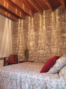 a bedroom with a stone wall and a bed at Amé-lys in Véraza