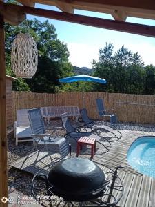 a patio with chairs and a table and a pool at Amé-lys in Véraza +16 photos