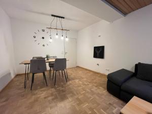 a living room with a table and a clock on the wall at Simplex Apartments Am Schwabentor in Freiburg im Breisgau