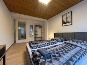 een slaapkamer met 2 bedden en een houten plafond bij Simplex Apartments Am Schwabentor in Freiburg im Breisgau