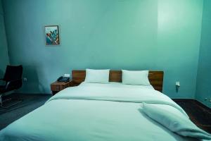a bedroom with a large white bed with a blue wall at Kigali viewStay in Kigali