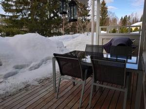 a table and chairs on a deck in the snow at Viihtyisä huoneisto Tahkolla in Tahkovuori