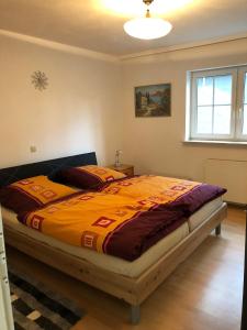 - une chambre avec un lit et une couette en orange dans l'établissement Unter den Weinbergen, à Treis-Karden