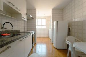 a white kitchen with a sink and a refrigerator at Apartamento 3 Quartos Central com Ar SQ41 in Maringá