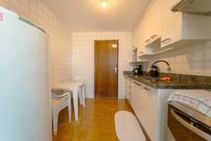 uma cozinha com um balcão e uma mesa em Apartamento 3 Quartos Central com Ar SQ41 em Maringá