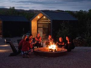 een groep mensen die rond een vuur zitten bij Ofland Escalante in Escalante