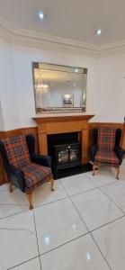 a living room with two chairs and a mirror at Loch Long Hotel in Arrochar