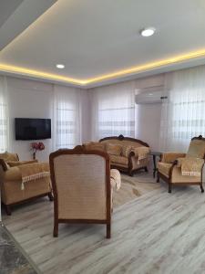 a living room with couches and a flat screen tv at VİLLA BELİNAY in Belek