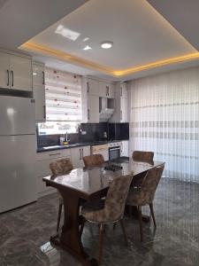 a kitchen with a table and chairs and a refrigerator at VİLLA BELİNAY in Belek