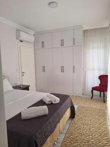 a bedroom with a large bed with towels on it at VİLLA BELİNAY in Belek