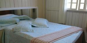 Casa Gralha Azul في لاجيز: غرفة نوم بسرير وملاءات ووسائد زرقاء