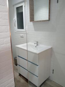 a white bathroom with a sink and a mirror at Apartamento El Cachorro de Triana in Seville