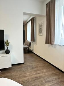 un soggiorno con pareti bianche e pavimenti in legno di Harmony Living - Graz Stadion Liebenau a Graz