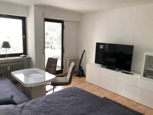 ein Wohnzimmer mit einem Flachbild-TV und einem Tisch in der Unterkunft Schwarzwald Apartment mit Terasse in Schönwald