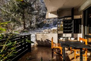 a dining room with a table and chairs on a patio at La belle Agathe, Vercors in Le Guâ