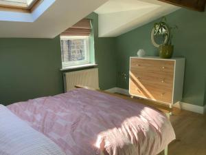 a bedroom with a bed and a dresser with a mirror at Time House Cottage in Huby
