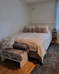 a bedroom with a large bed with pillows on it at Harstad city studio apartment B. in Harstad