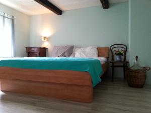 um quarto com uma cama com um cobertor azul em Hisa Suzana em Črnomelj