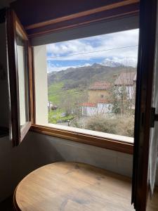 a window with a table in a room with a view at La Ventana de Picos in Onís