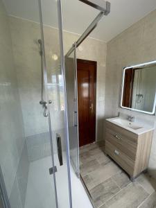 ein Bad mit einer Dusche und einem Waschbecken in der Unterkunft La Ventana de Picos in Onís