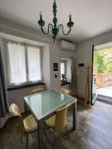 a dining room with a glass table and chairs at Casa Batty in Sori