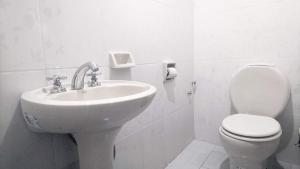 ein weißes Bad mit einem Waschbecken und einem WC in der Unterkunft HOTEL IDEAL in Villazón