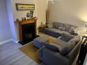a living room with a couch and a fireplace at No. 7 Lissadell Holiday Home in Portstewart
