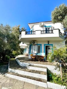 a white house with stairs leading up to it at Villa Kastri I with a romantic view in Kámpos