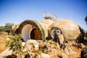 a large dome house with a door on a hill at Casa Ballena, Finca La Lama Romana Bodonal de la Sierra in Bodonal de la Sierra