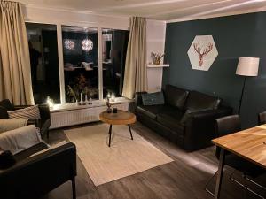 a living room with a couch and a table at Chalet de Bosrand 404, unieke rustige plek met veel privacy aan de bosrand van vakantiepark op de Veluwe in Beekbergen