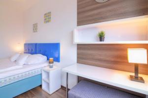 1 dormitorio con 1 cama y escritorio con lámpara en High Tower Szczecin en Szczecin