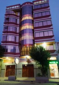 ein hohes Gebäude mit einer Uhr davor in der Unterkunft HOTEL IDEAL in Villazón