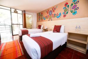 a hotel room with two beds and a window at Mayu Boutique Hotel in Cusco