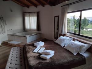 Hibisco Home Hotel في أوروبيسي: غرفة نوم بسرير كبير وحوض استحمام