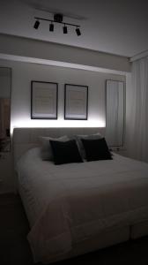 een slaapkamer met een wit bed met een licht erboven bij RIVER VIEW & CENTRAL LOCATION - private sauna & glazed balcony in Rovaniemi