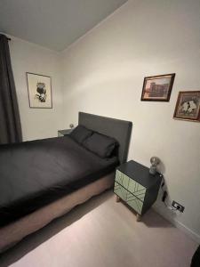 Schlafzimmer mit einem Bett und einem Beistelltisch in der Unterkunft Prato Home - apartment near the beach in Menton in Menton