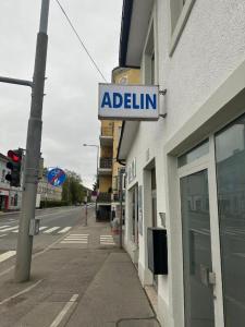 una señal para un edificio al lado de una calle en Adelin Vienna, en Viena
