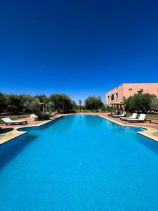 ein großer Pool mit blauem Wasser in einem Resort in der Unterkunft Guest House Qodwa in Marrakesch