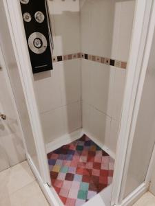 a bathroom with a shower with a colorful floor at VIVIENDA de uso TURISTICO in Bóveda