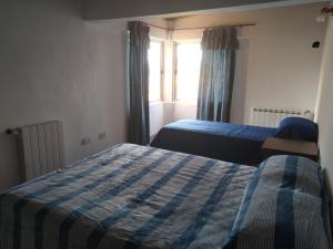 a bedroom with two beds and a window at La Escondida in Ushuaia