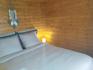 a bedroom with a bed with a wooden wall at Winiec Mobile Home in Miłomłyn