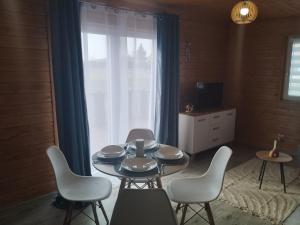 a dining room with a table and chairs and a window at Winiec Mobile Home in Miłomłyn