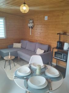 a living room with a couch and a table with plates at Winiec Mobile Home in Miłomłyn