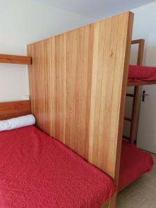 1 dormitorio con 1 cama con cabecero de madera en Studio Front de Neige, en Le Dévoluy
