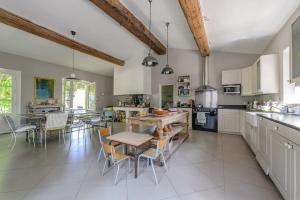 een grote keuken met een houten tafel en stoelen bij Mas provençal avec piscine et tennis in Oppède