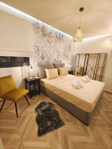 een slaapkamer met een groot bed en een stoel bij Volos Guesthouse Konstantina in Volos