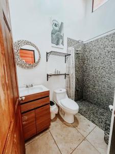 a bathroom with a toilet and a sink and a shower at Casa sin Tiempo in Uvita